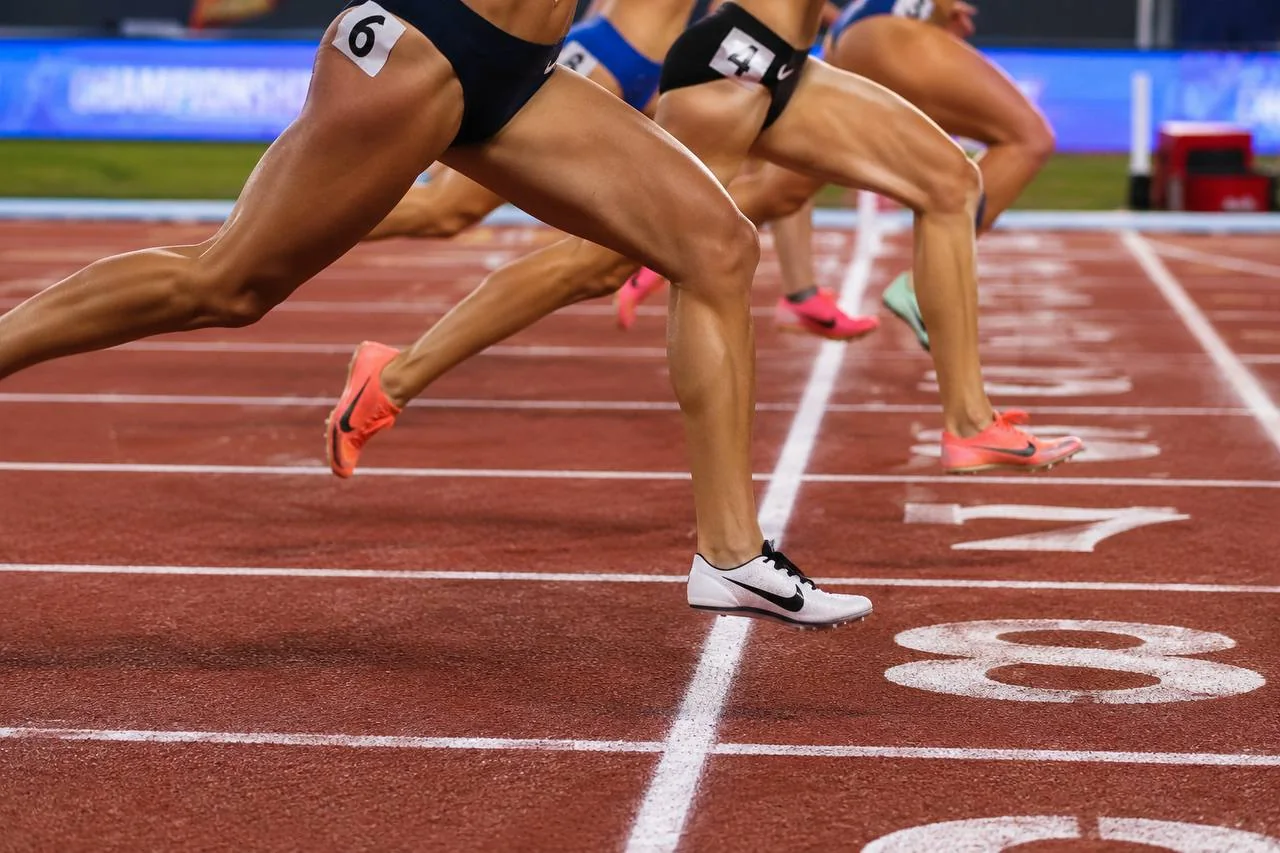 Female middle distance runners accelerating on a track, representing elite 800 metre racing